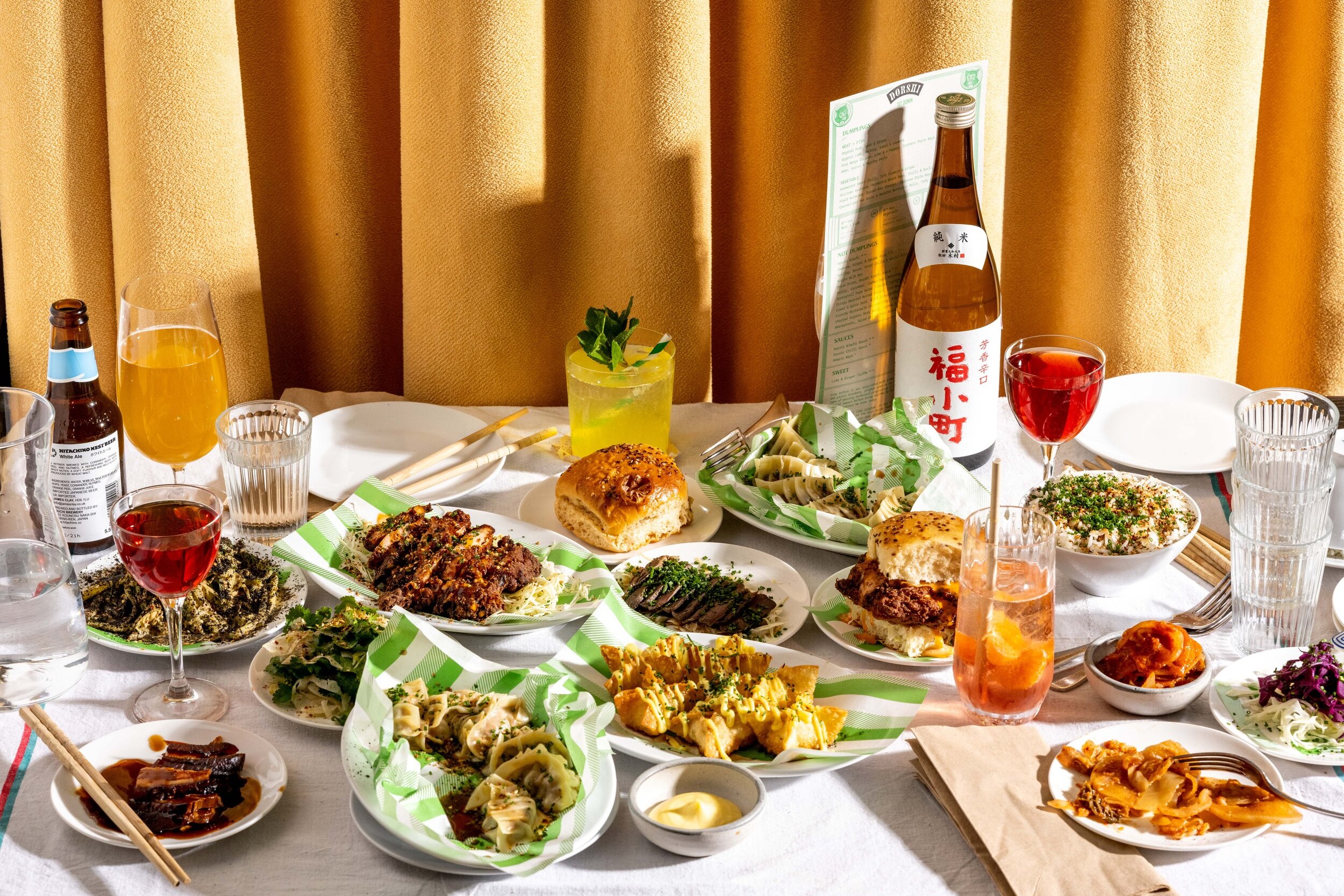 Small plates of dumplings and a Japanese sake bottle on a table at Dorshi, Bridport