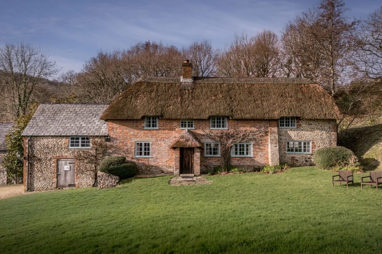 Thatched brick farmhouse with a lawn at Shedbush Farm House, near Bridport, Dorset